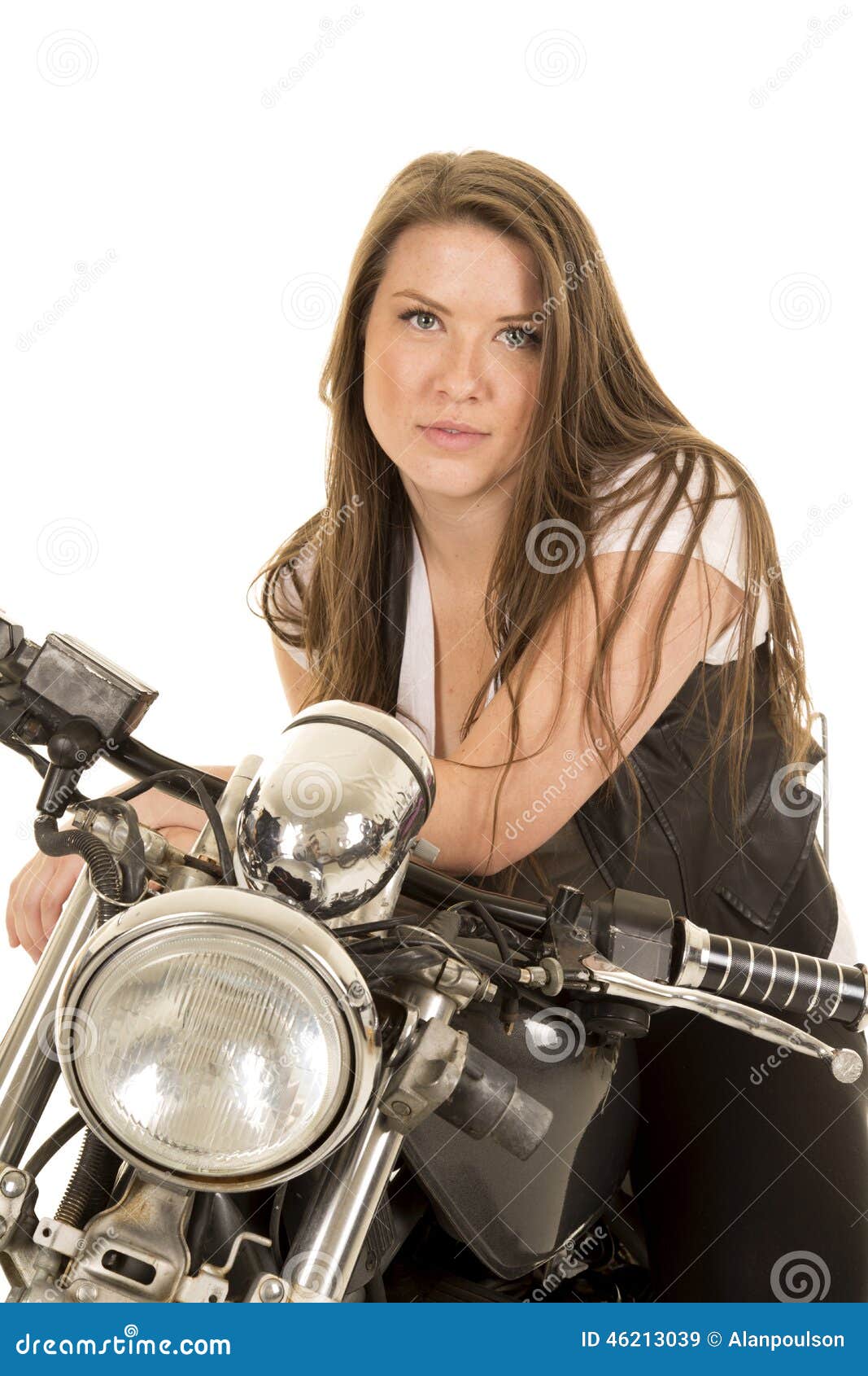 Woman black vest motorcycle facing serious close. A woman in her black vest sitting on her motorcycle.