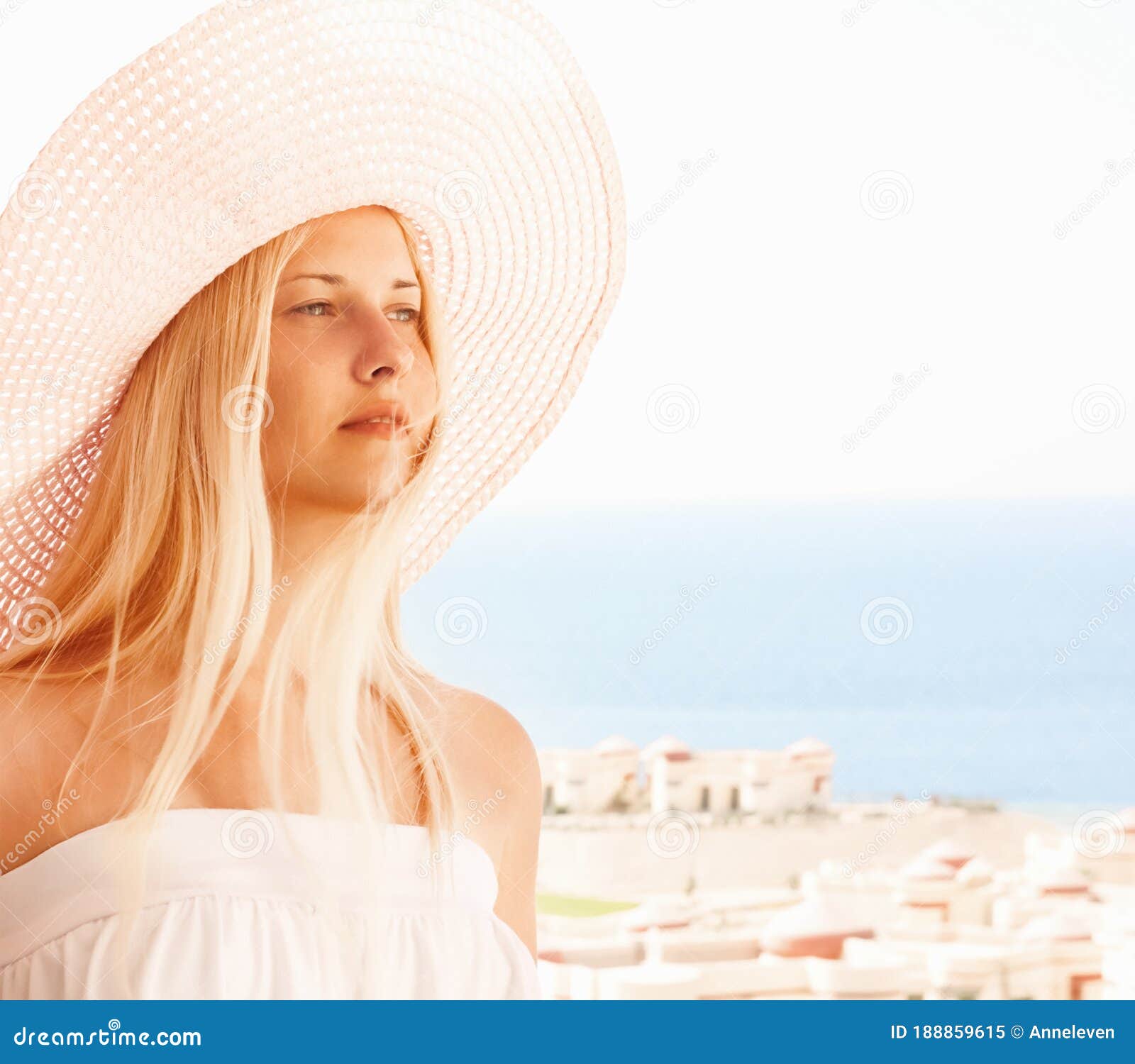 Woman With Blond Hair Wearing Hat Enjoying Seaside And Beach Lifestyle In Summertime Holiday