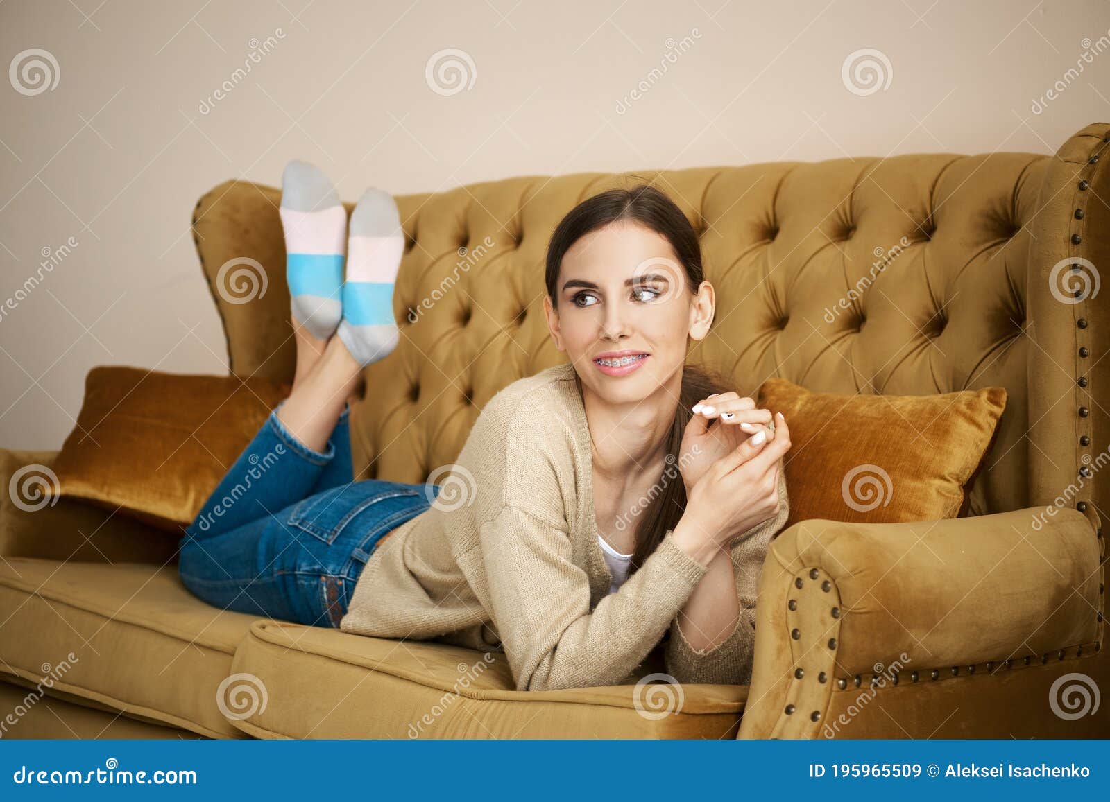 girl on couch relaxing in living room and recalling pleasant moments