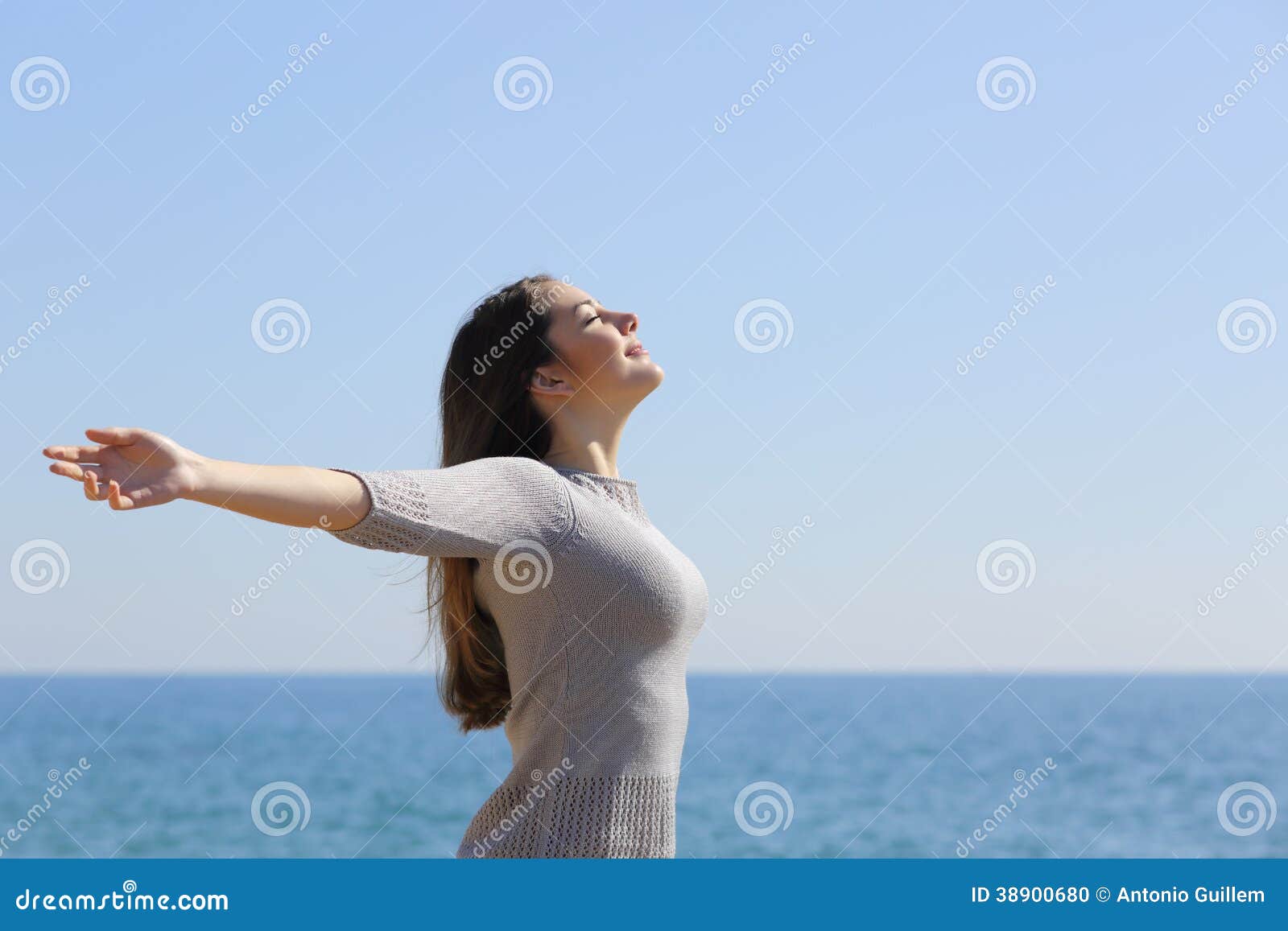 woman breathing deep fresh air and raising arms