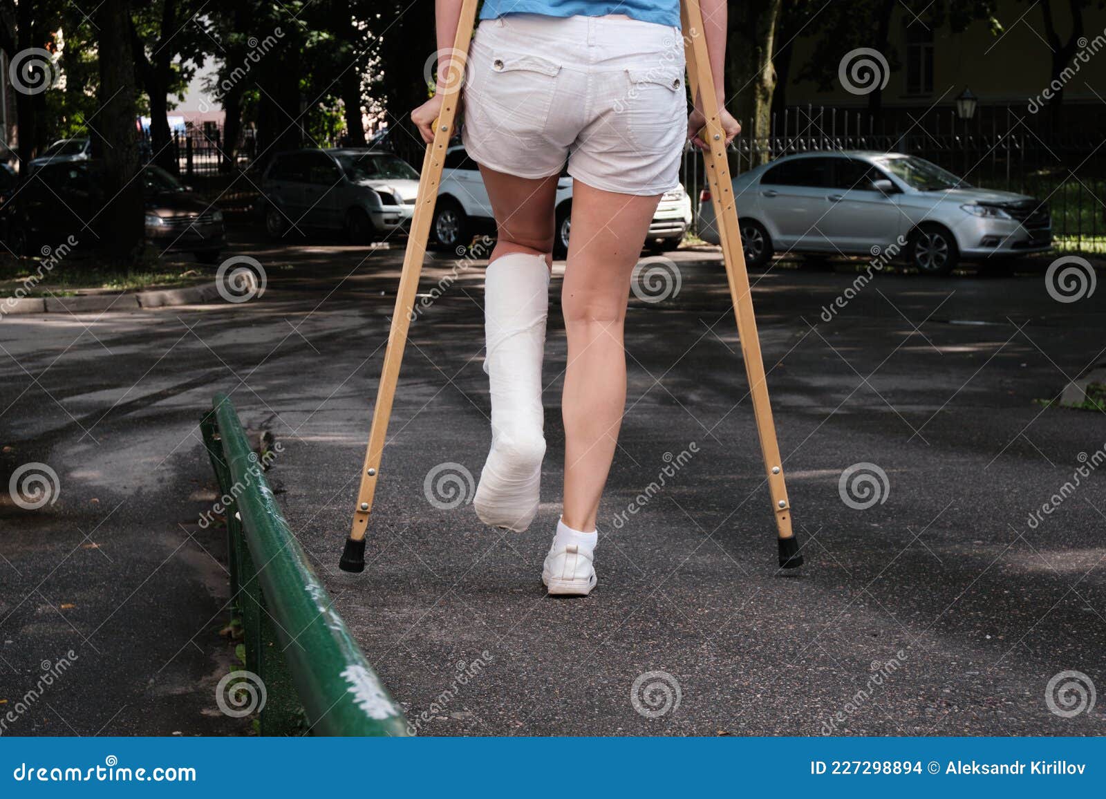 A Woman With A Broken Leg Walks Down A Ramp Using Orthopedic Crutches A Woman With A Broken Leg Walks Down A Ramp Using Orthopedic Crutches
