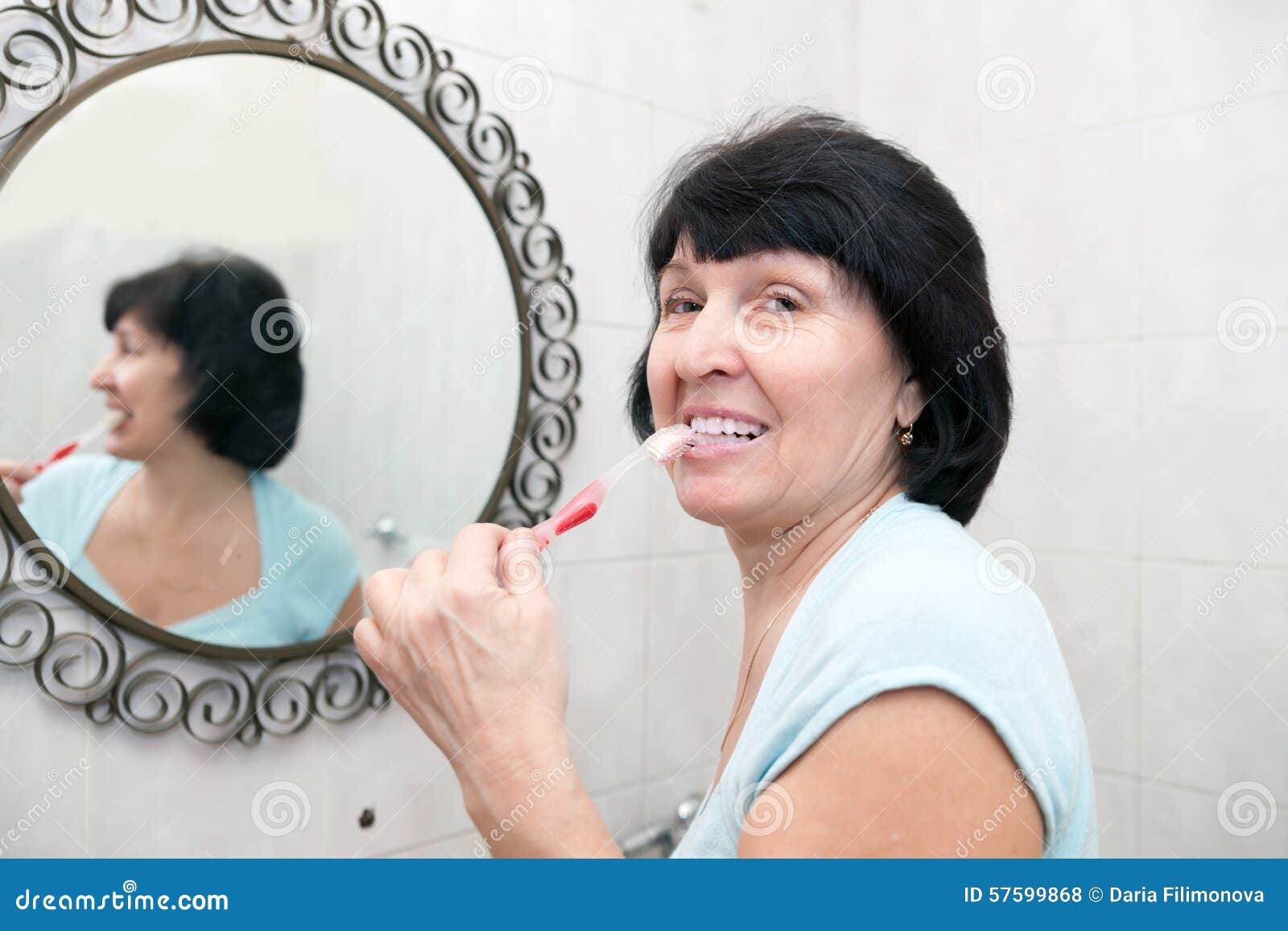 Woman Brushing Her Teeth in Bathroom. Stock Photo Image of adult