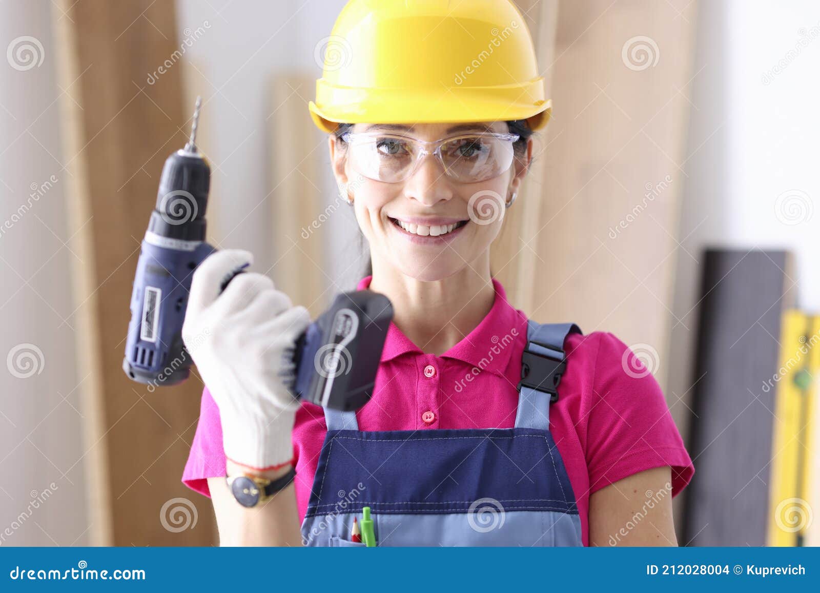 Woman Builder in Protective Helmet Holding Drill in Her Hands Stock
