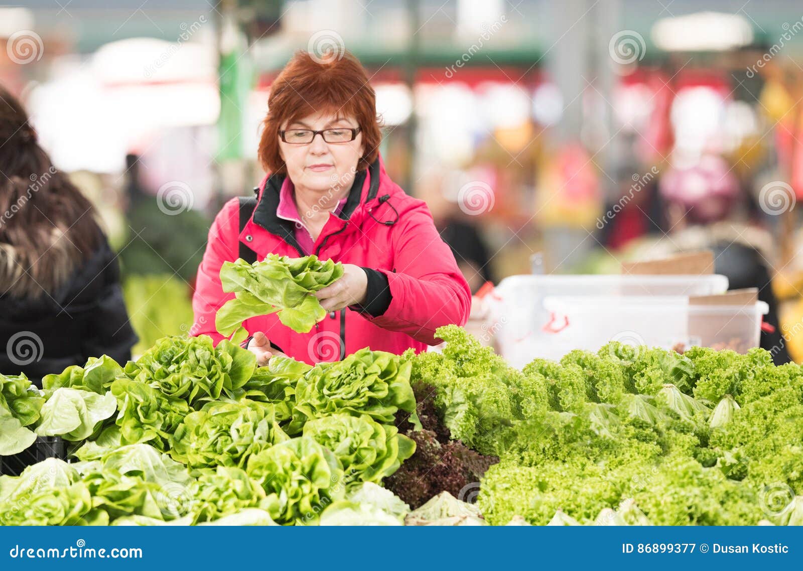 woman buying lettuce at market place