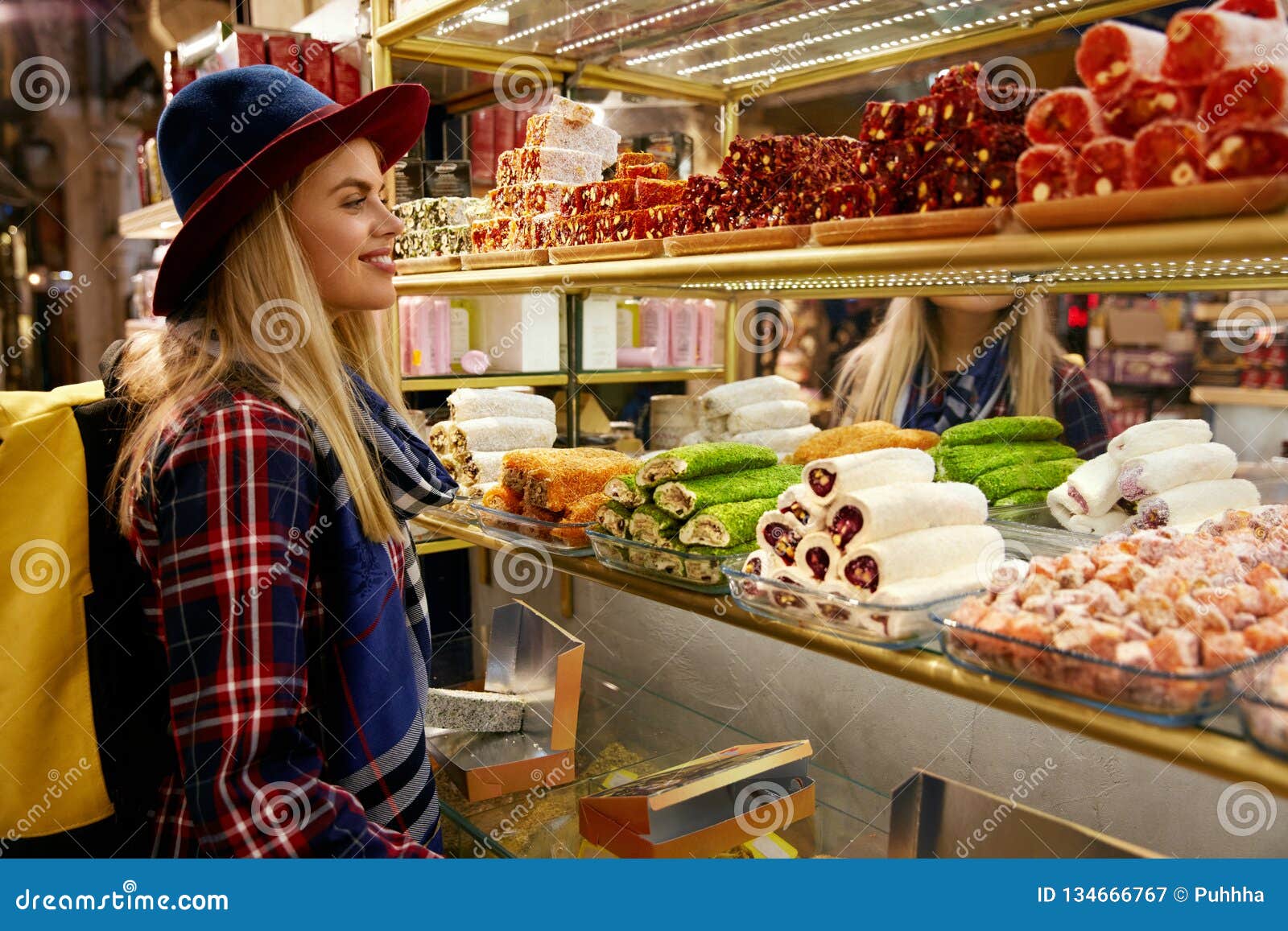 woman buying turkish sweets at eastern food market