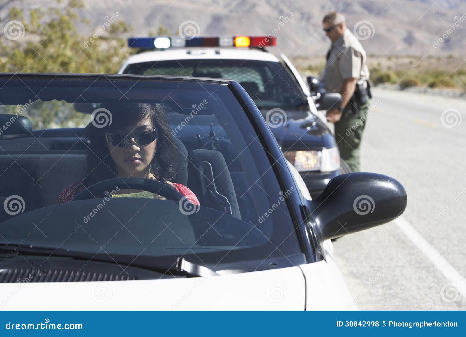 woman in car being pulled over by police officer