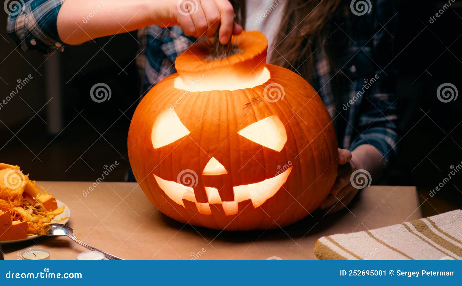 woman carving jack o lantern pumpkin for halloween