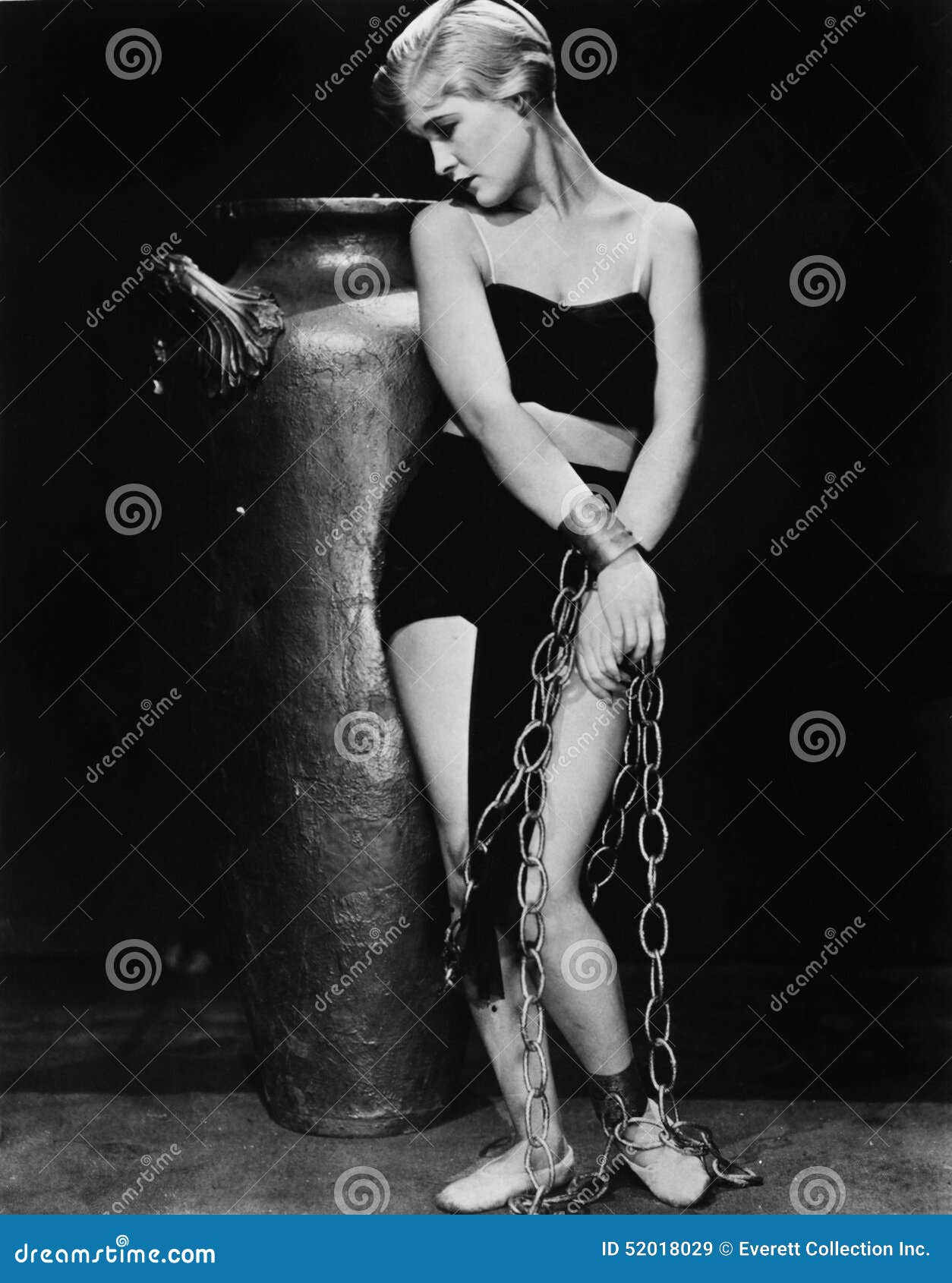 woman chained in front of a big vase