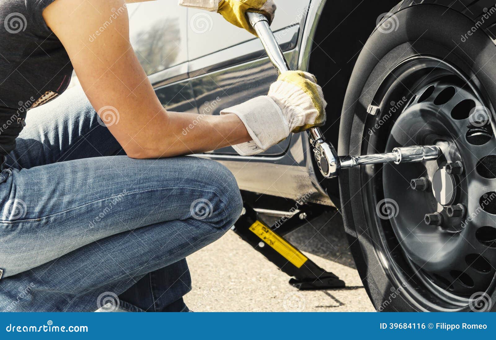 woman changing tire car