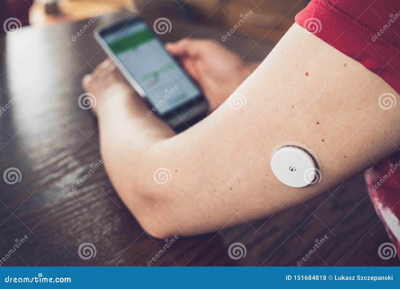 woman checking glucose level with a remote sensor and mobile phone, sensor checkup glucose levels without blood.