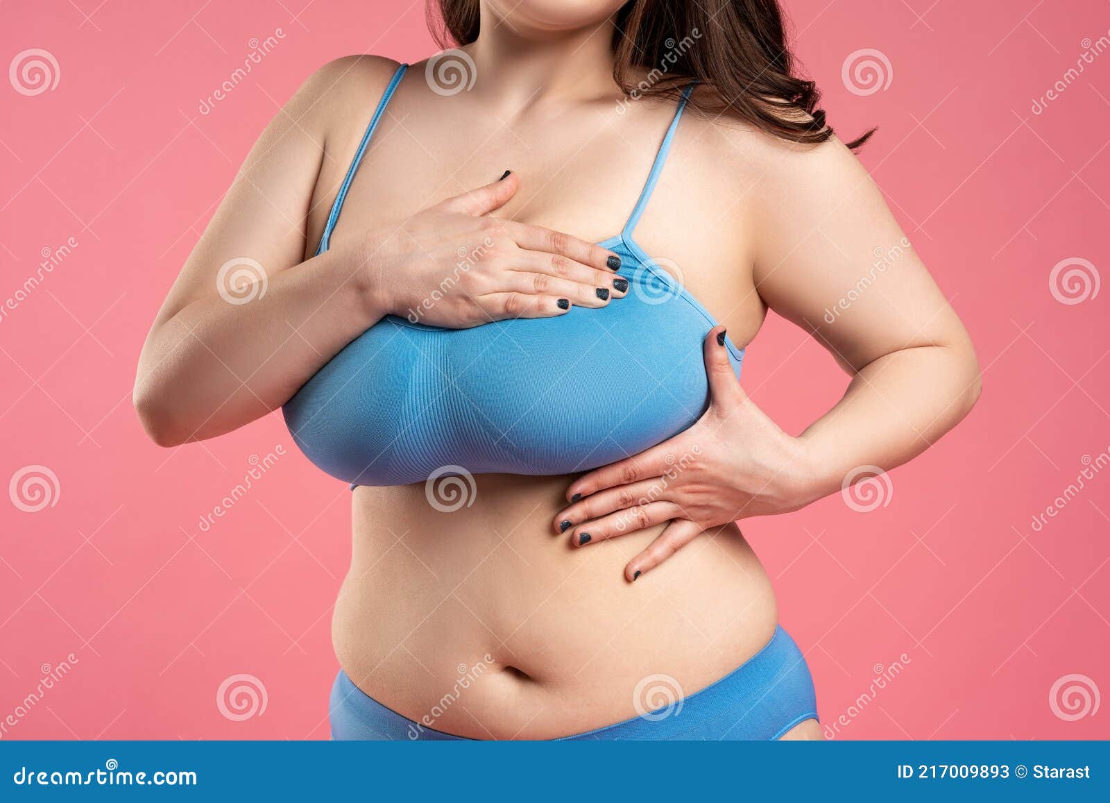 Woman Checking Her Very Large Breasts for Cancer on Pink