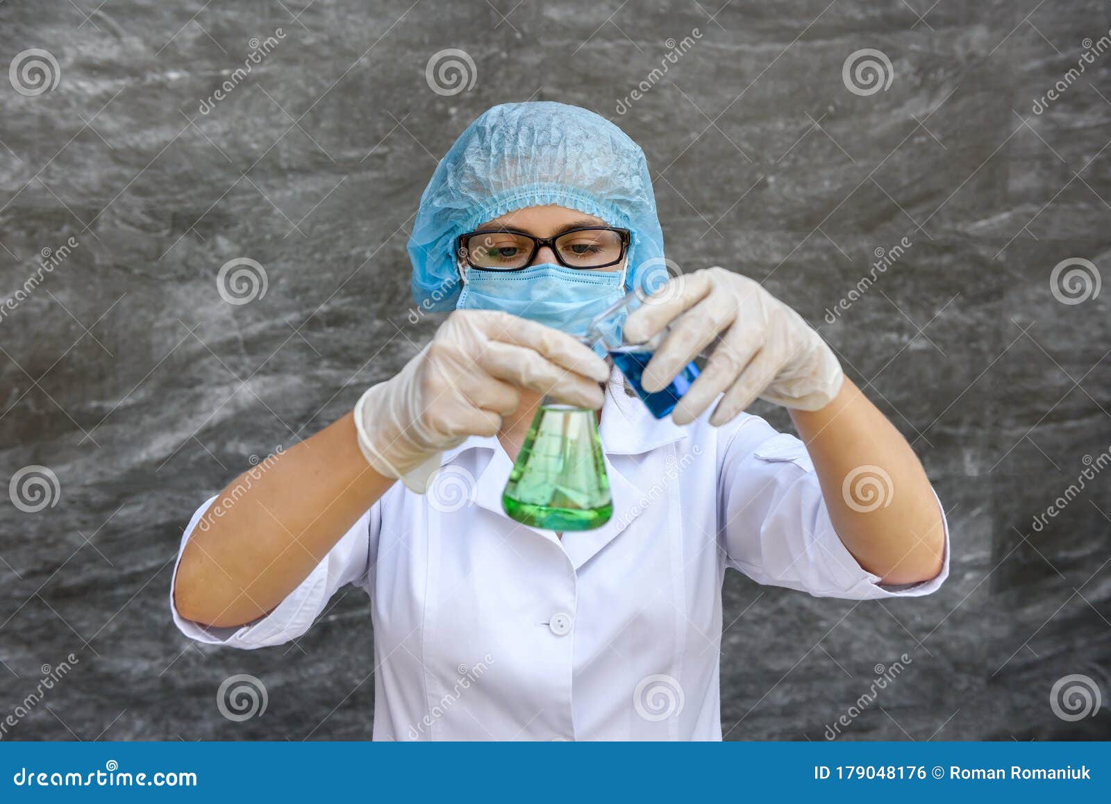 Woman Chemist with Test Tubes and Protective Uniform Making Experiment