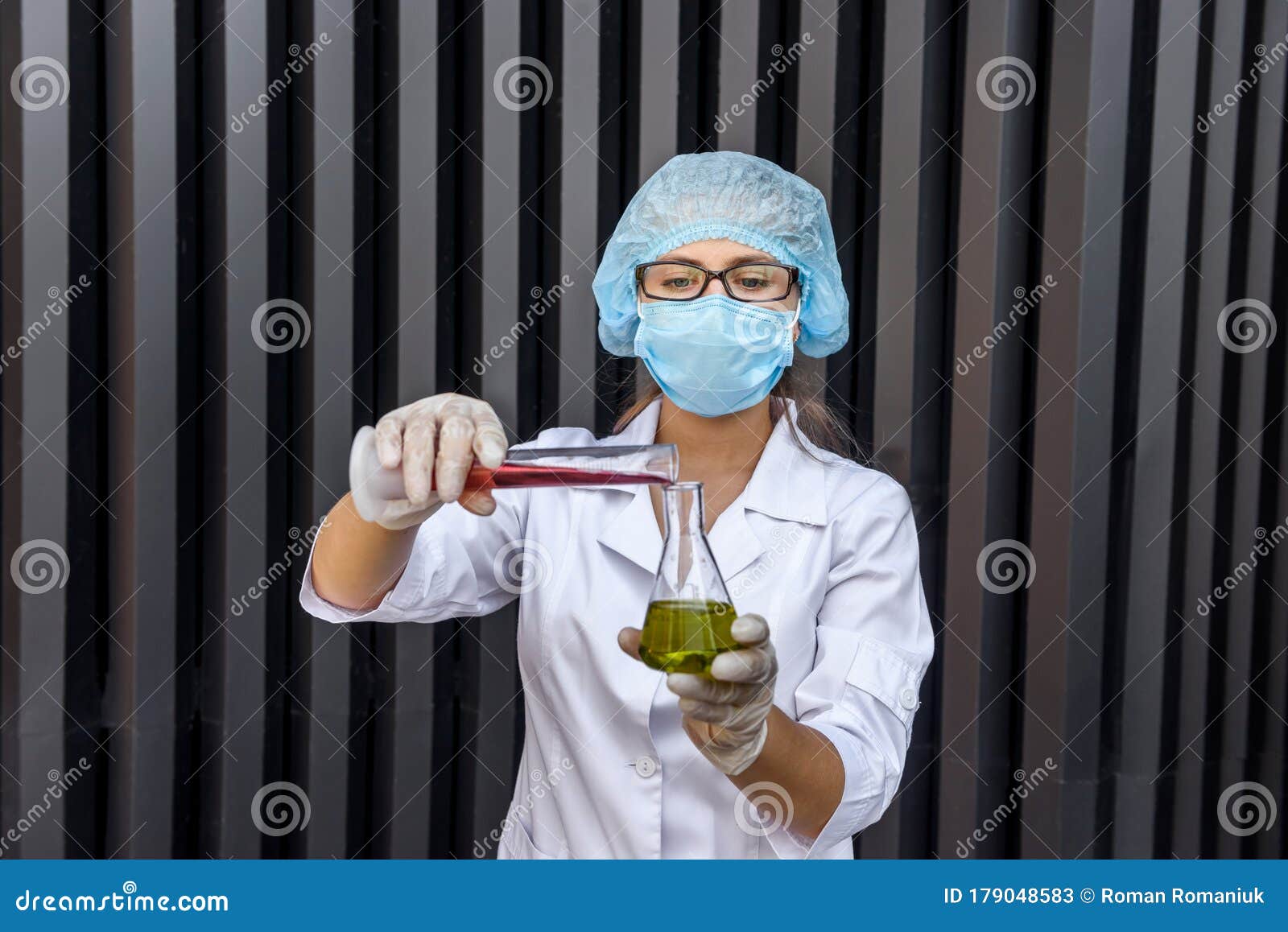 Woman Chemist with Test Tubes and Protective Uniform Making Experiment with Two Substance Stock