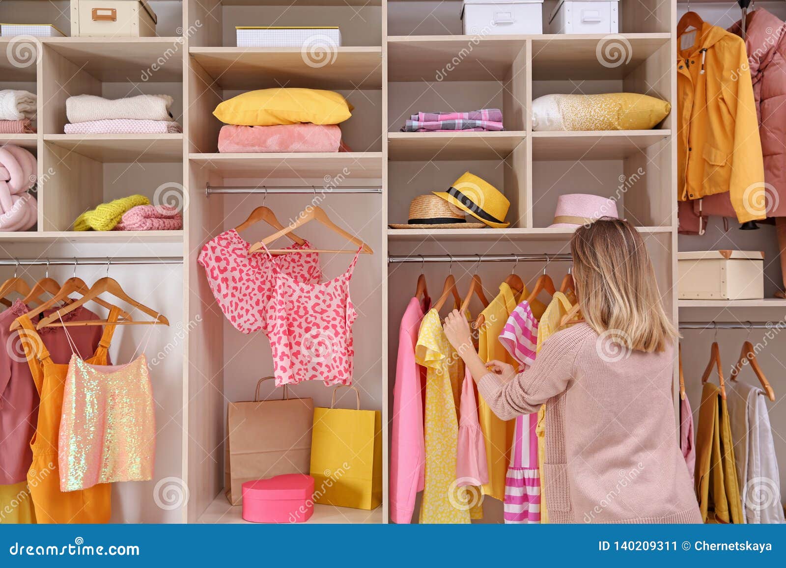 woman choosing clothes from large wardrobe