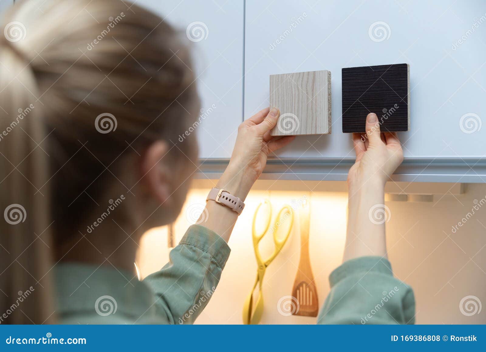 woman choosing kitchen cabinet materials from laminate samples