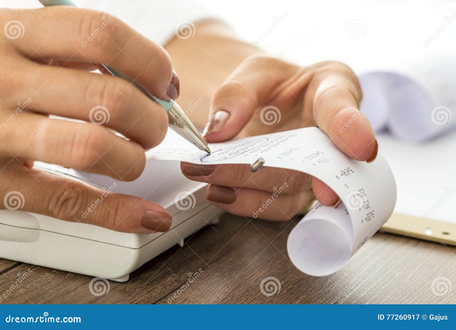 woman circling numbers on paper receipt