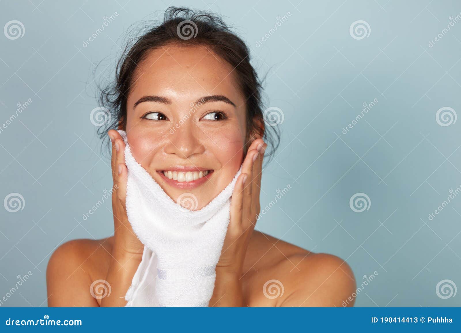 woman cleaning facial skin with towel after washing face portrait