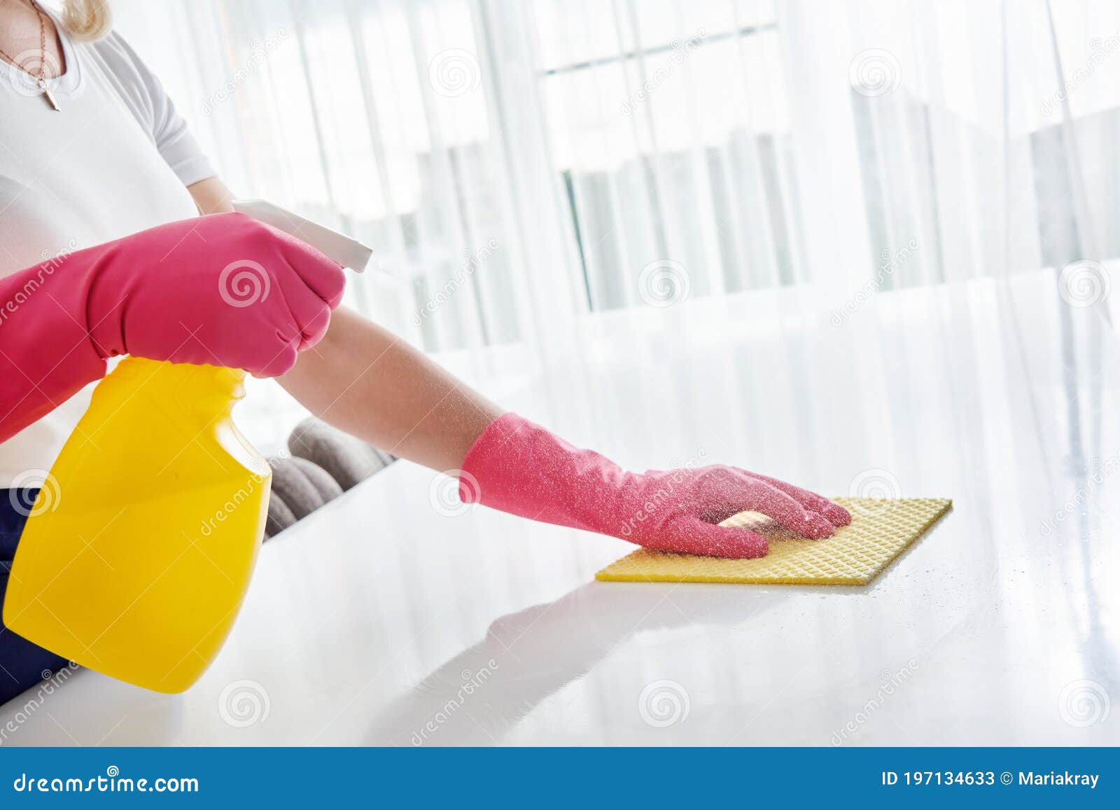 Cleaner woman cleaning kitchen counter with cloth, spray bottle and rubber  gloves in modern home in Stock Photo by YuriArcursPeopleimages