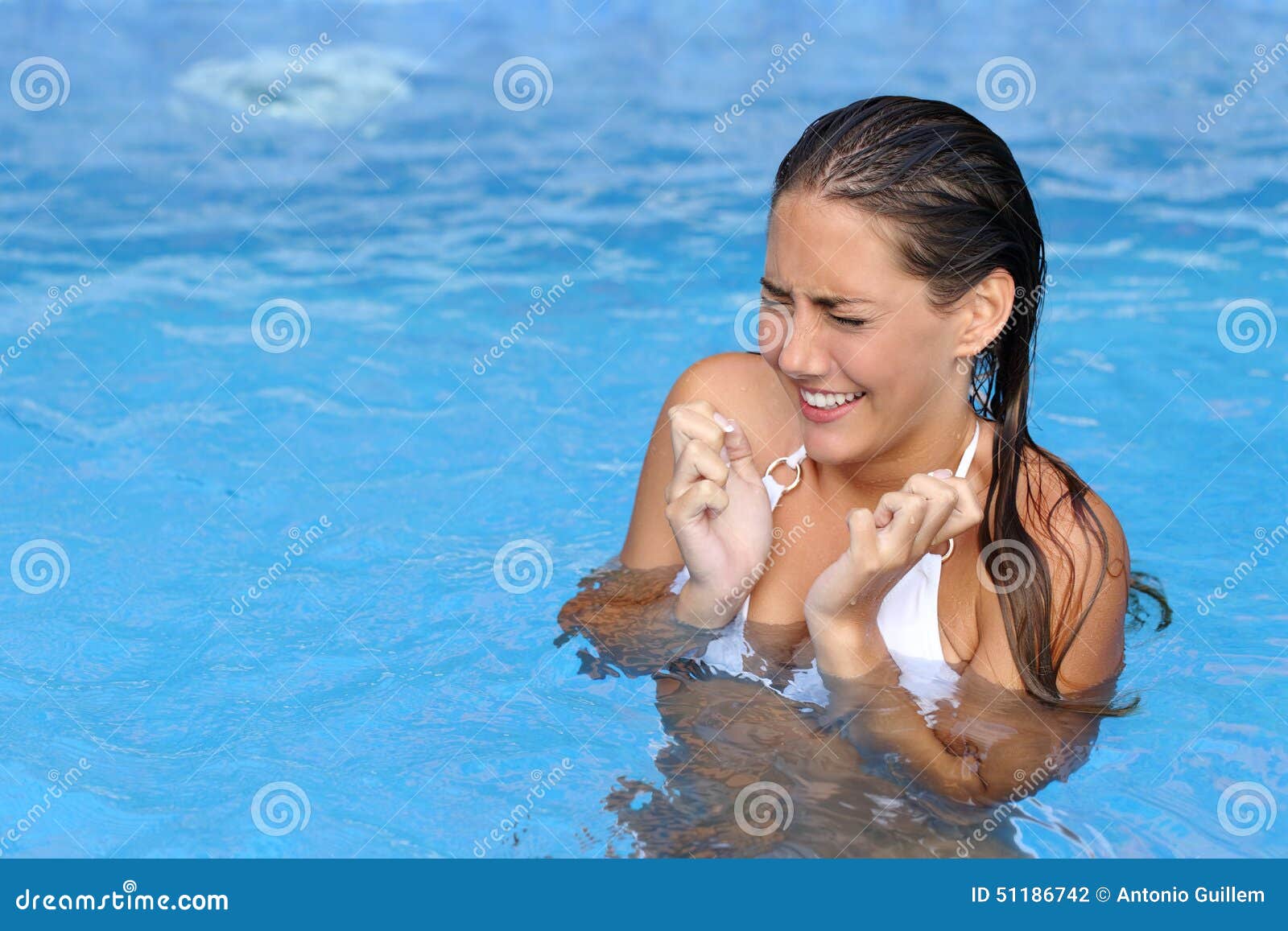 woman complaints in a cold water of a swimming pool