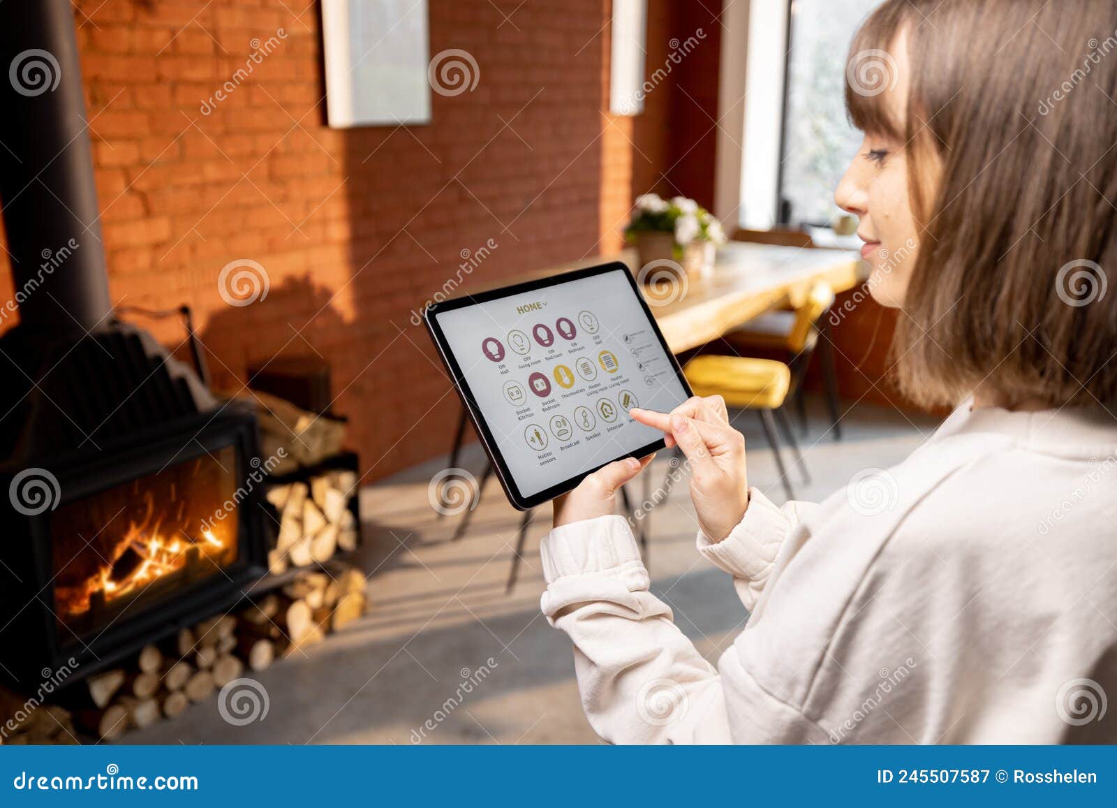 woman controlling home devices remotely by using smart home app on digital tablet at home