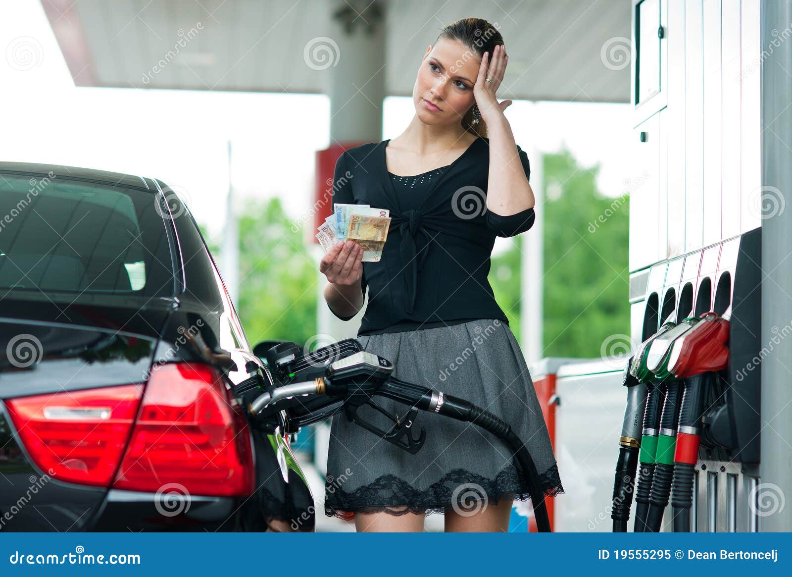 woman counting money on gas station