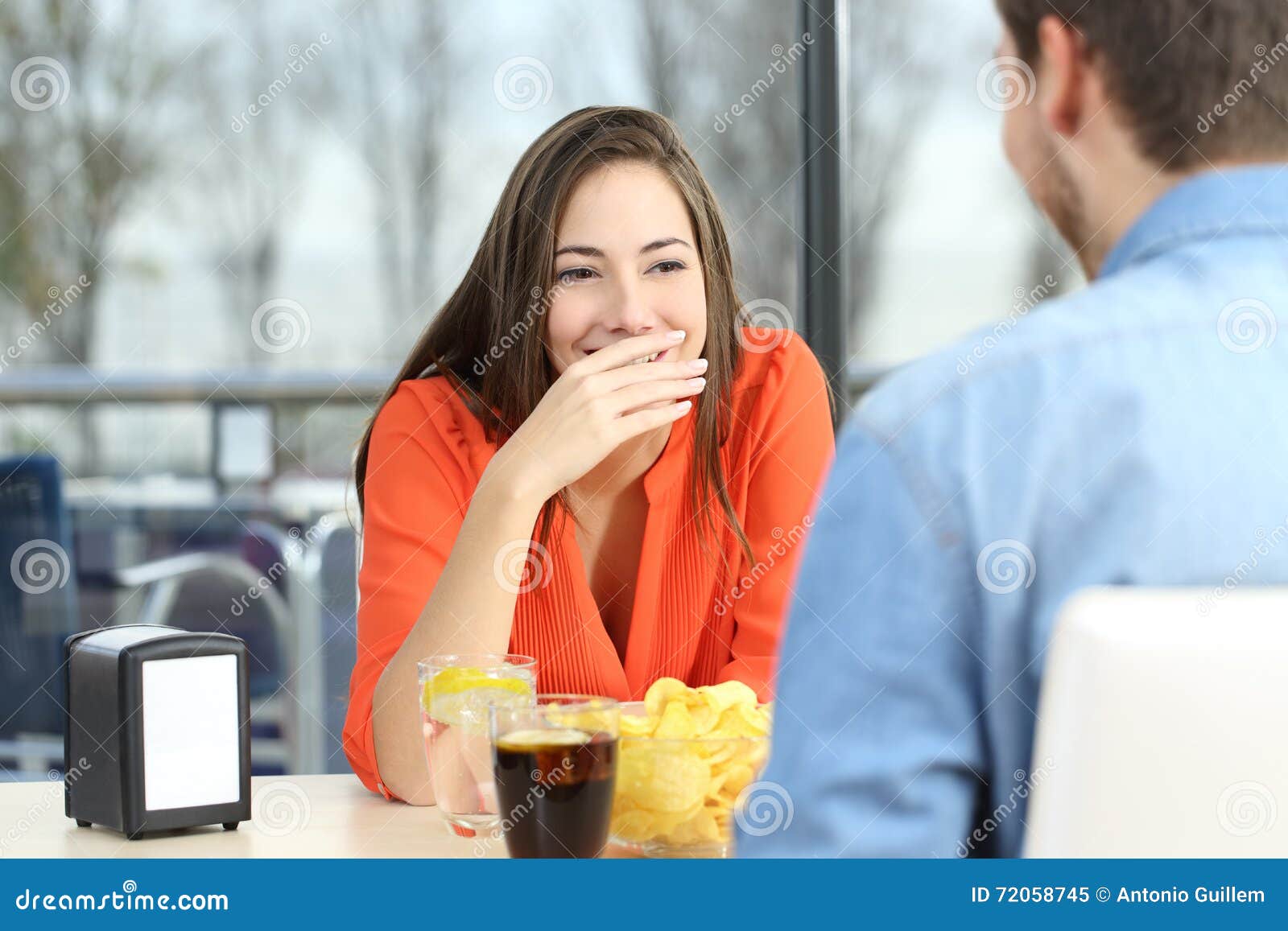 woman covering her mouth to hide smile or breath