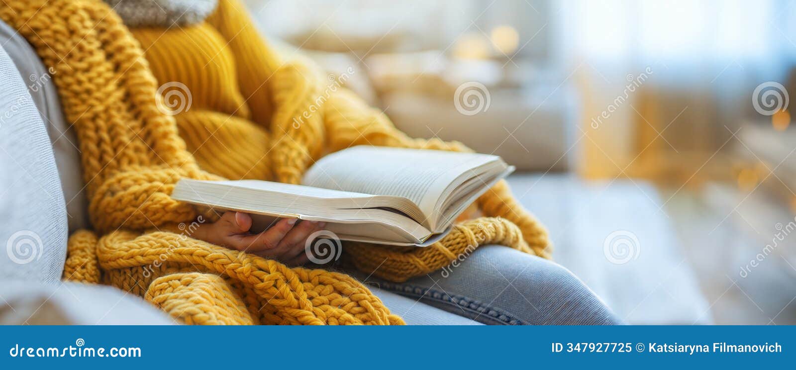 woman in a cozy yellow sweater reading a book on a sofa in a warm, relaxed atmosphere.