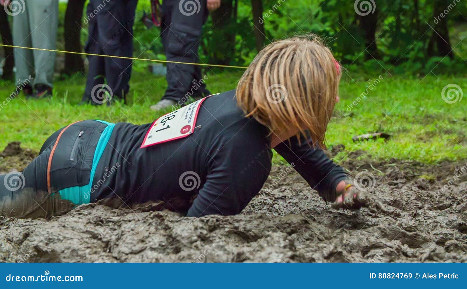 Woman Crawling through Mud As Part of Obstacle Course Stock Video