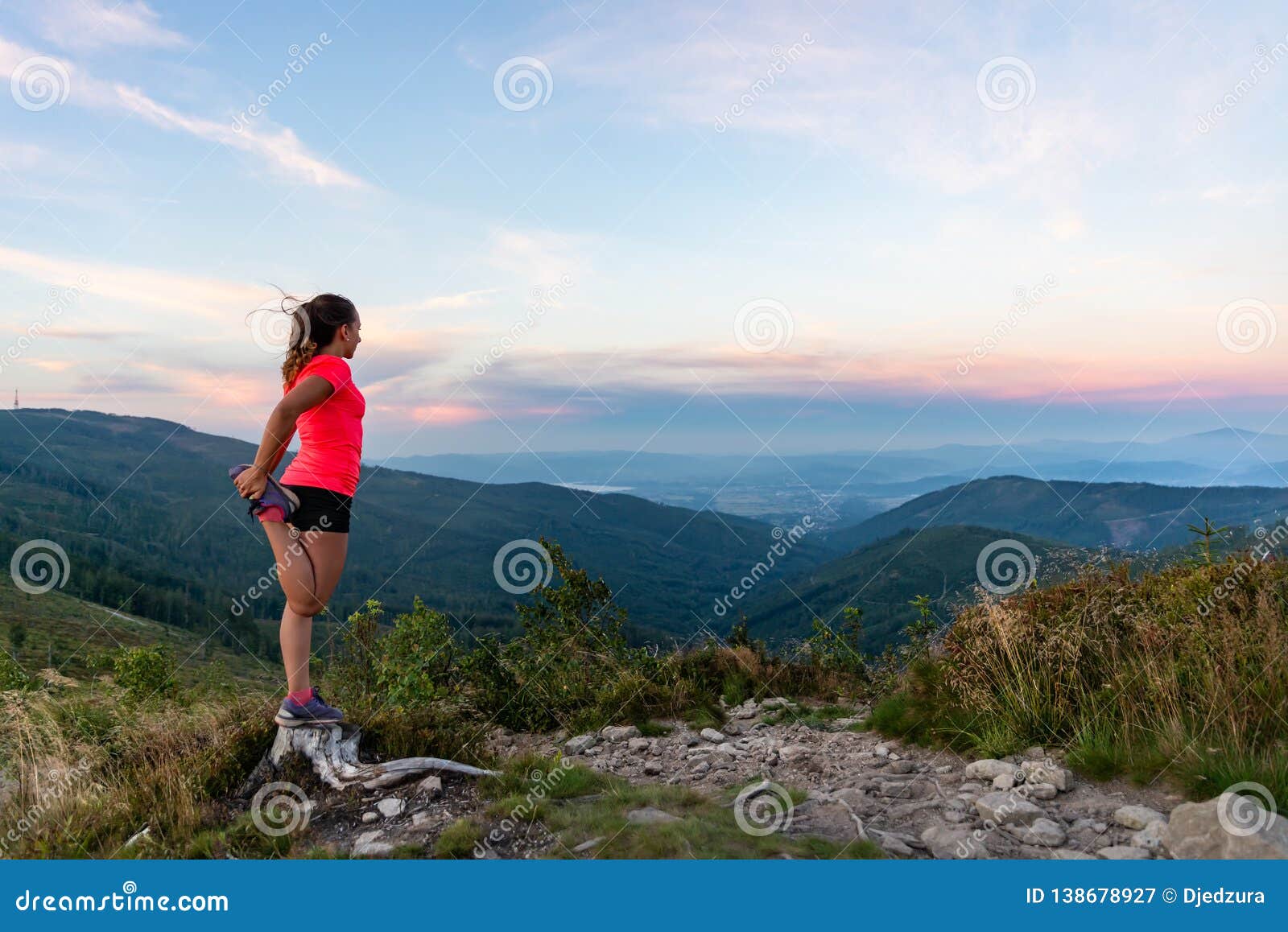 woman cross country runner quads stretching in mountains at summer
