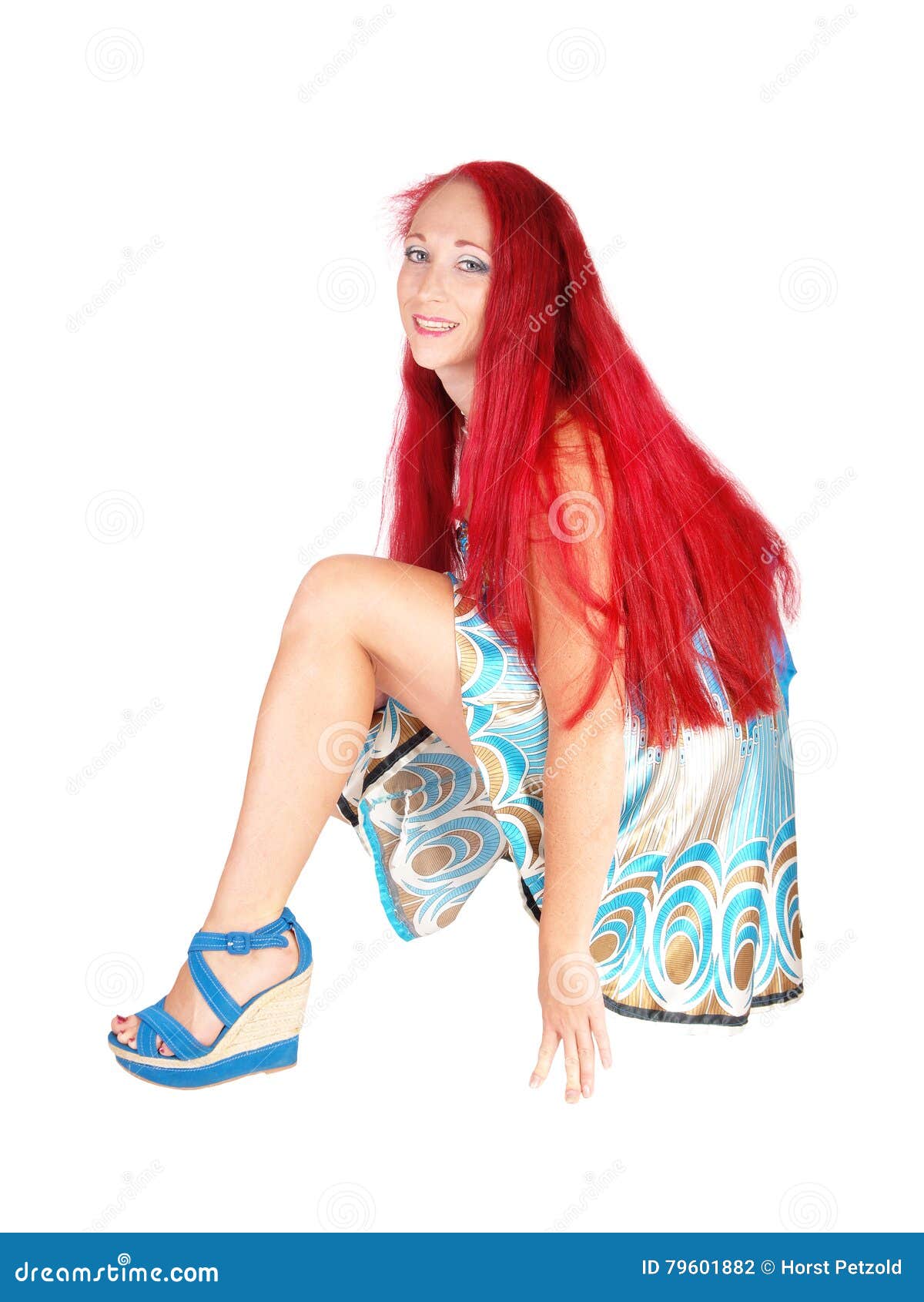 A lovely woman in a short dress and black leggings crouching on the floor  with her long red hair, isolated for white background Stock Photo - Alamy