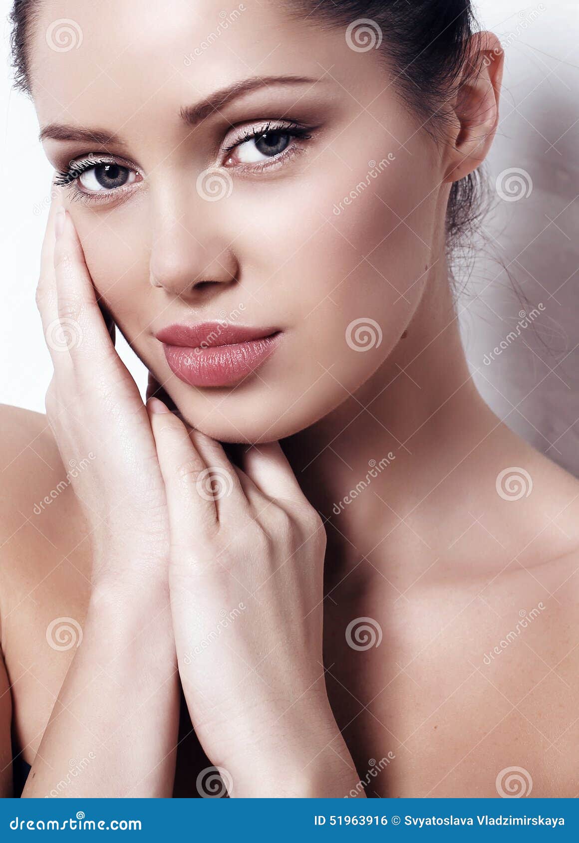 woman with dark hair with natural makeup and radiance health skin posing