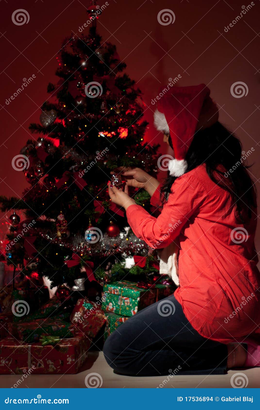 woman decorate christmas tree in night