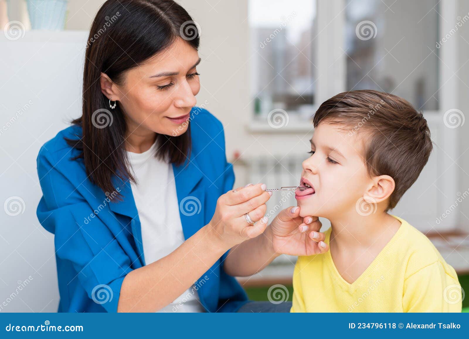 A Woman Develops a Tongue for a Boy with a Speech Therapy Probe Stock