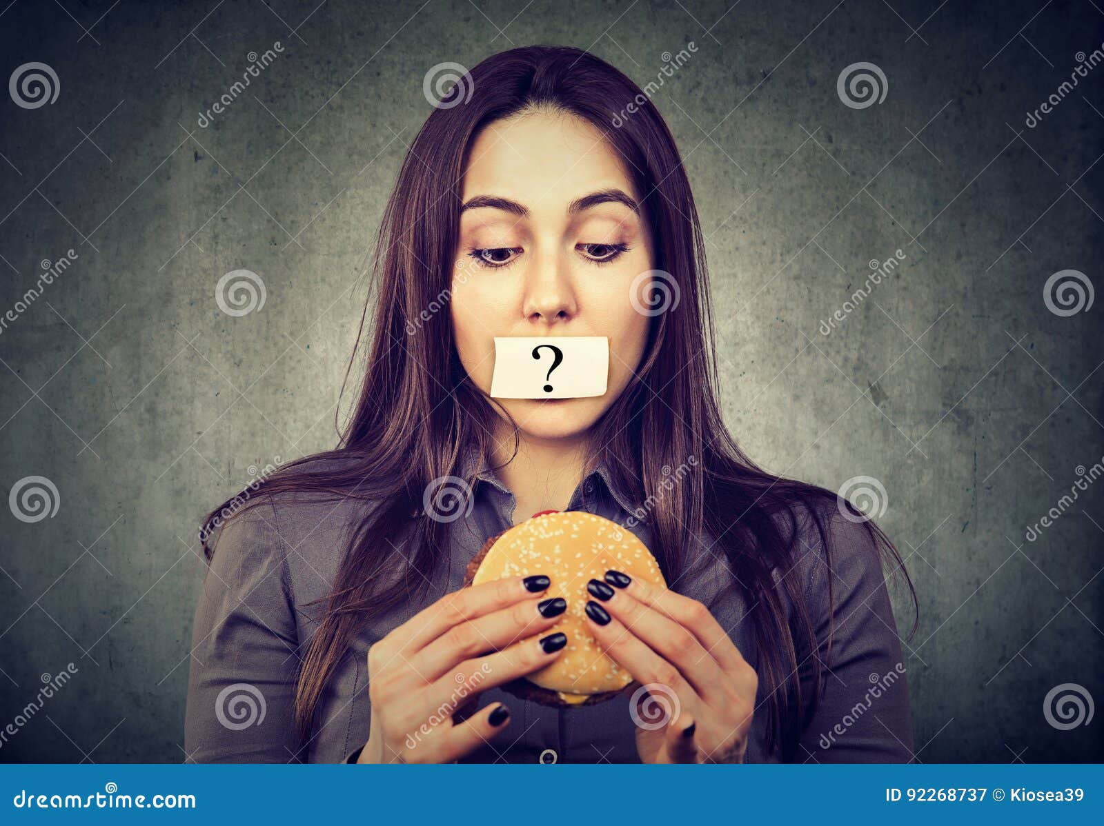 woman on diet restriction with question mark on mouth looking at burger