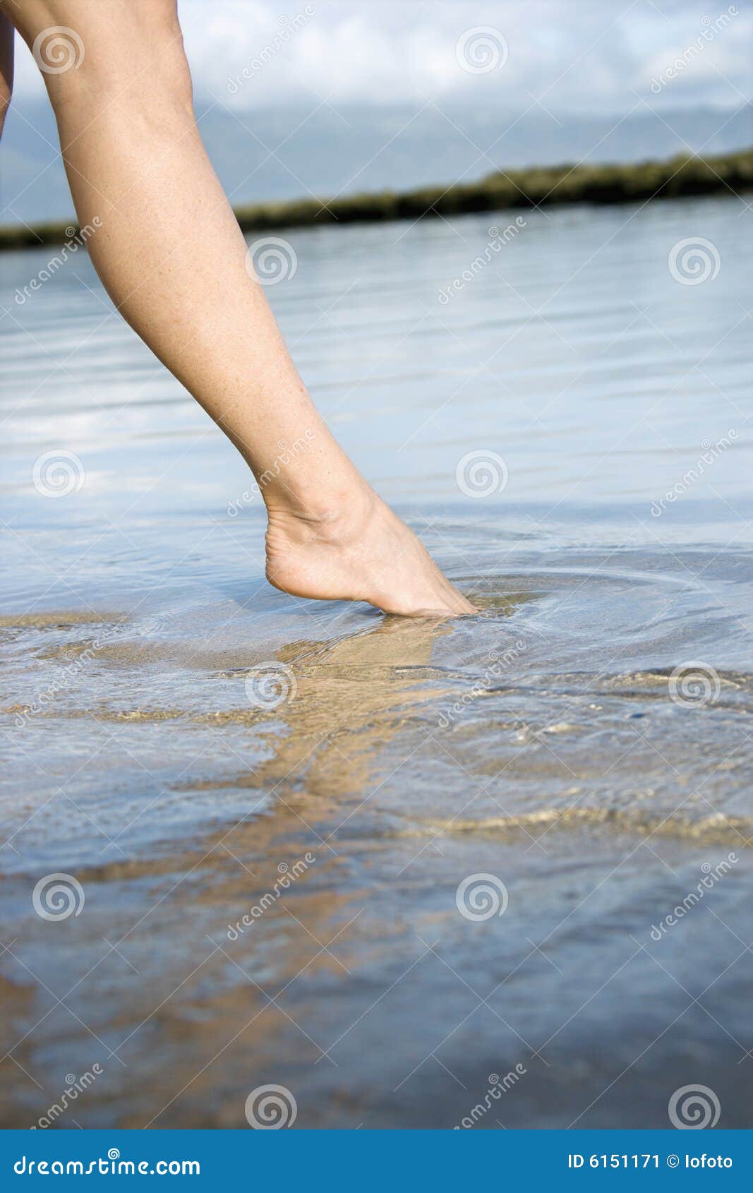woman dipping toe in water.