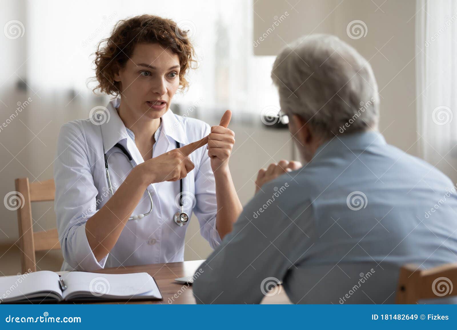 woman doctor consulting senior patient at medical visit in hospital