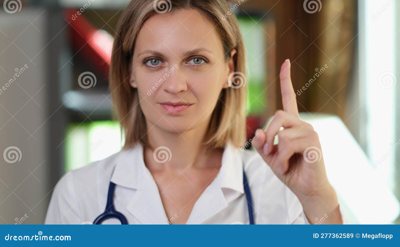 woman doctor pointing finger up in medical office