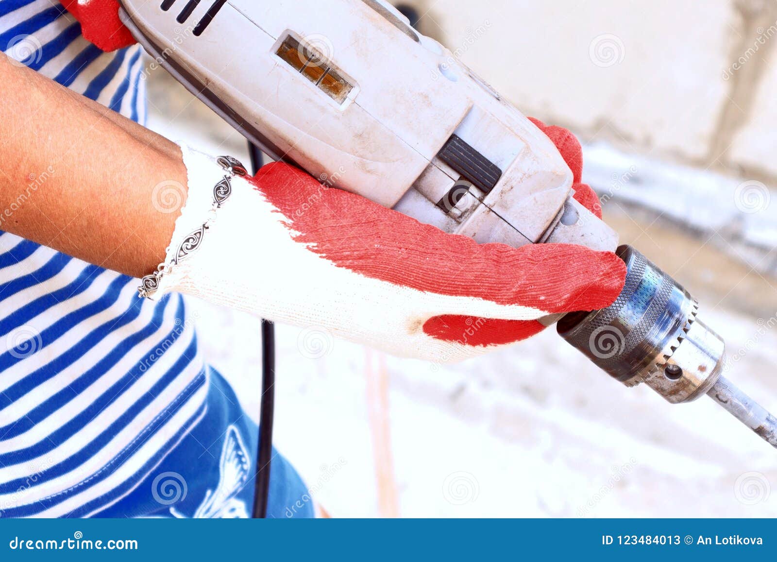 A Woman Doing a Man`s Job To Drill with a Special Tool, Drill in Hand