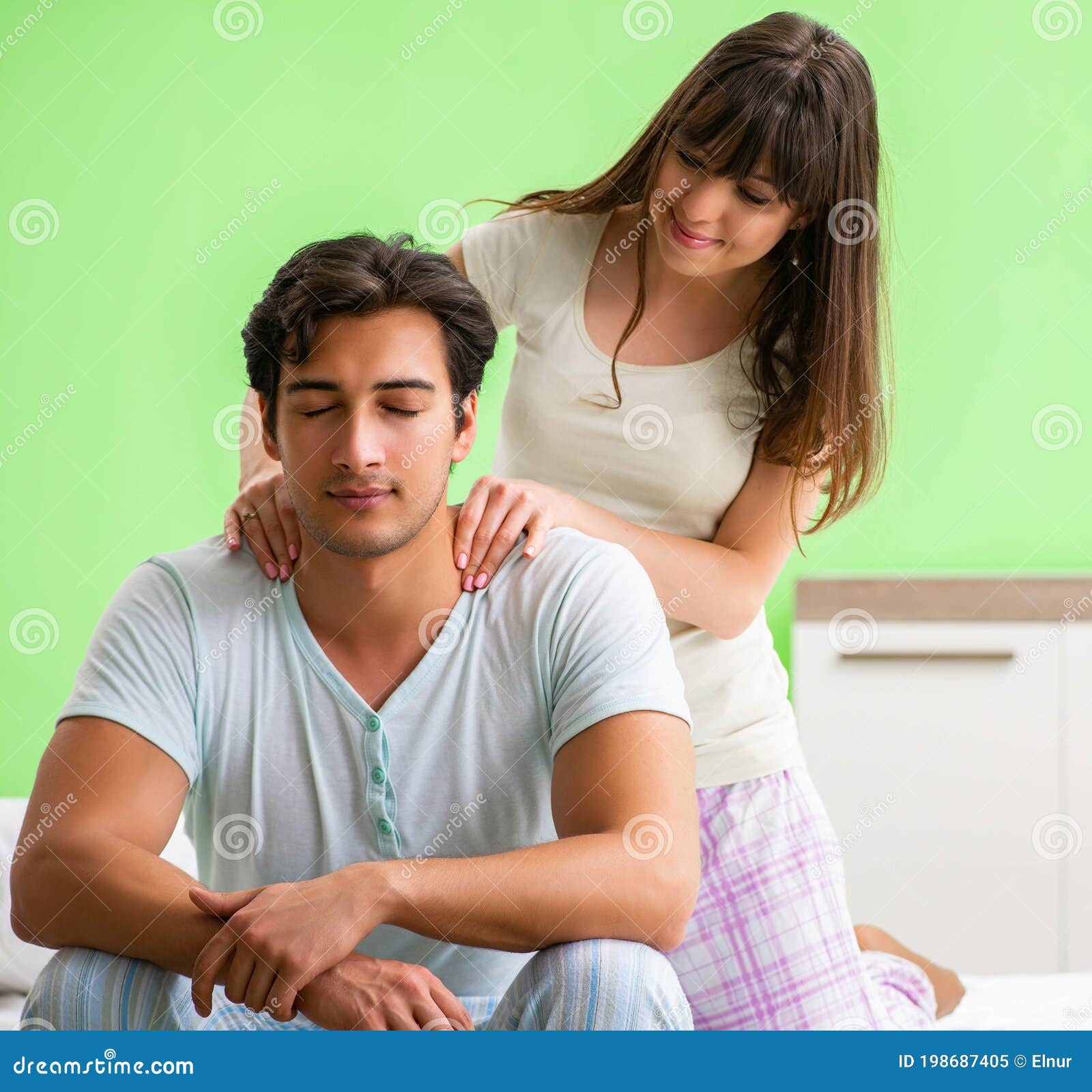 Woman Doing Massage To Her Husband in Bedroom Stock Image