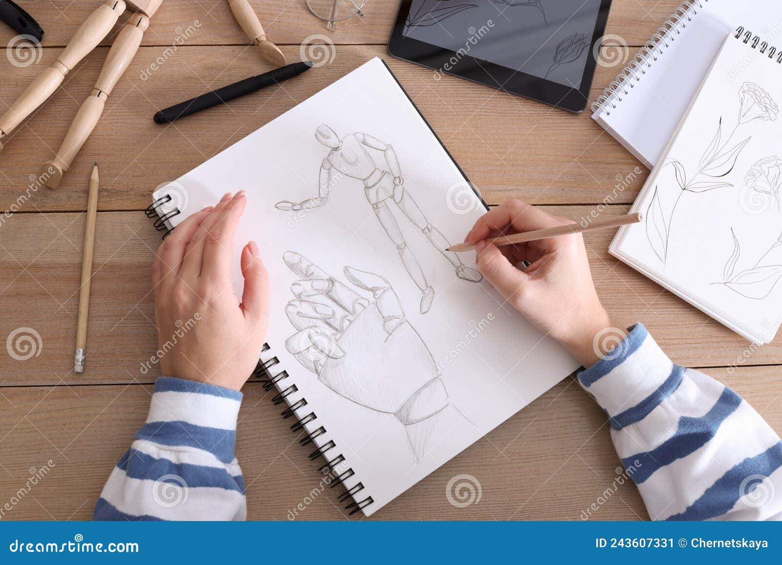 Woman Drawing in Sketchbook with Pencil at Wooden Table, Top View