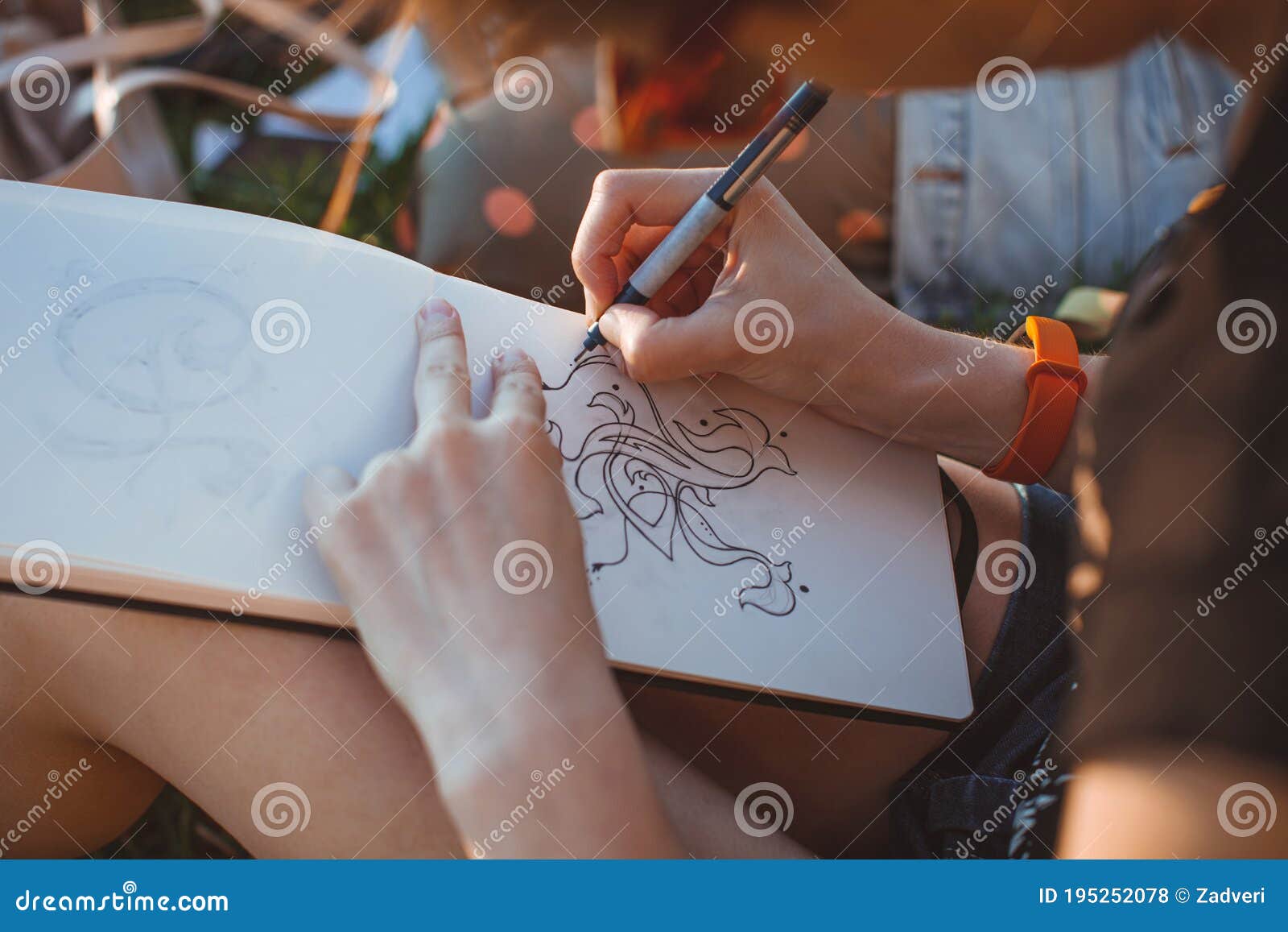 woman draws letters in the park. outline hand lettering in a sketchbook