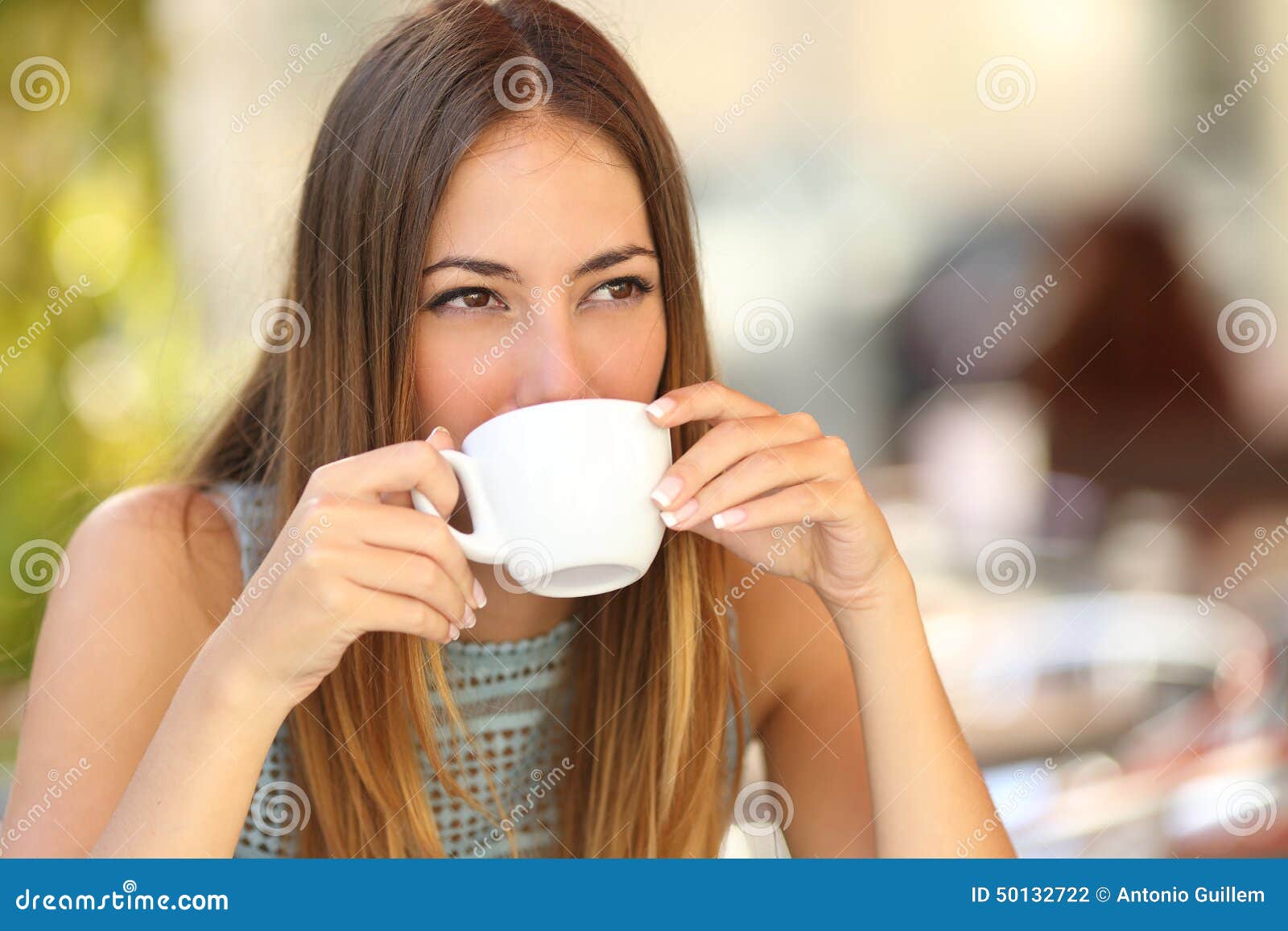 woman drinking a coffee from a cup in a restaurant terrace