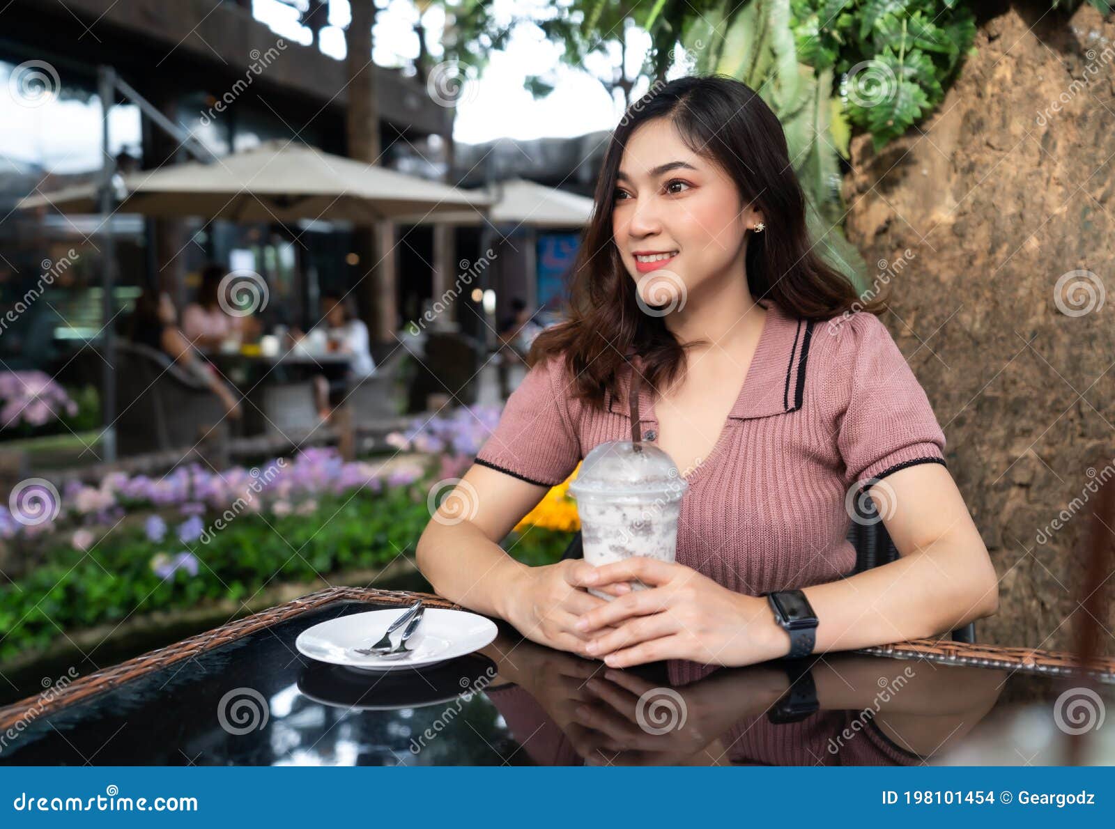 woman drinking iced milk frappe in a cafe