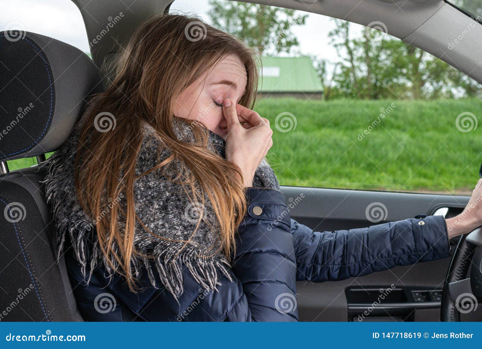 woman driving overtired car and rubbing her eyes