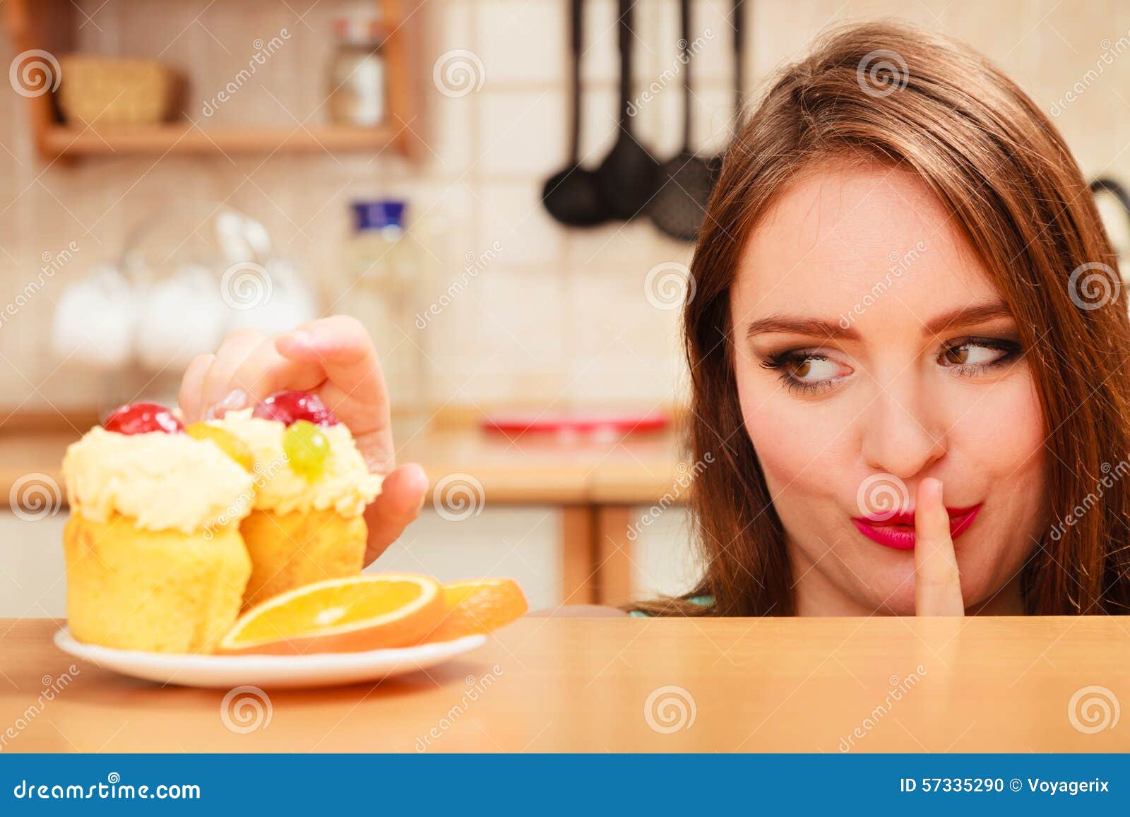 woman eating cake showing quiet sign. gluttony.