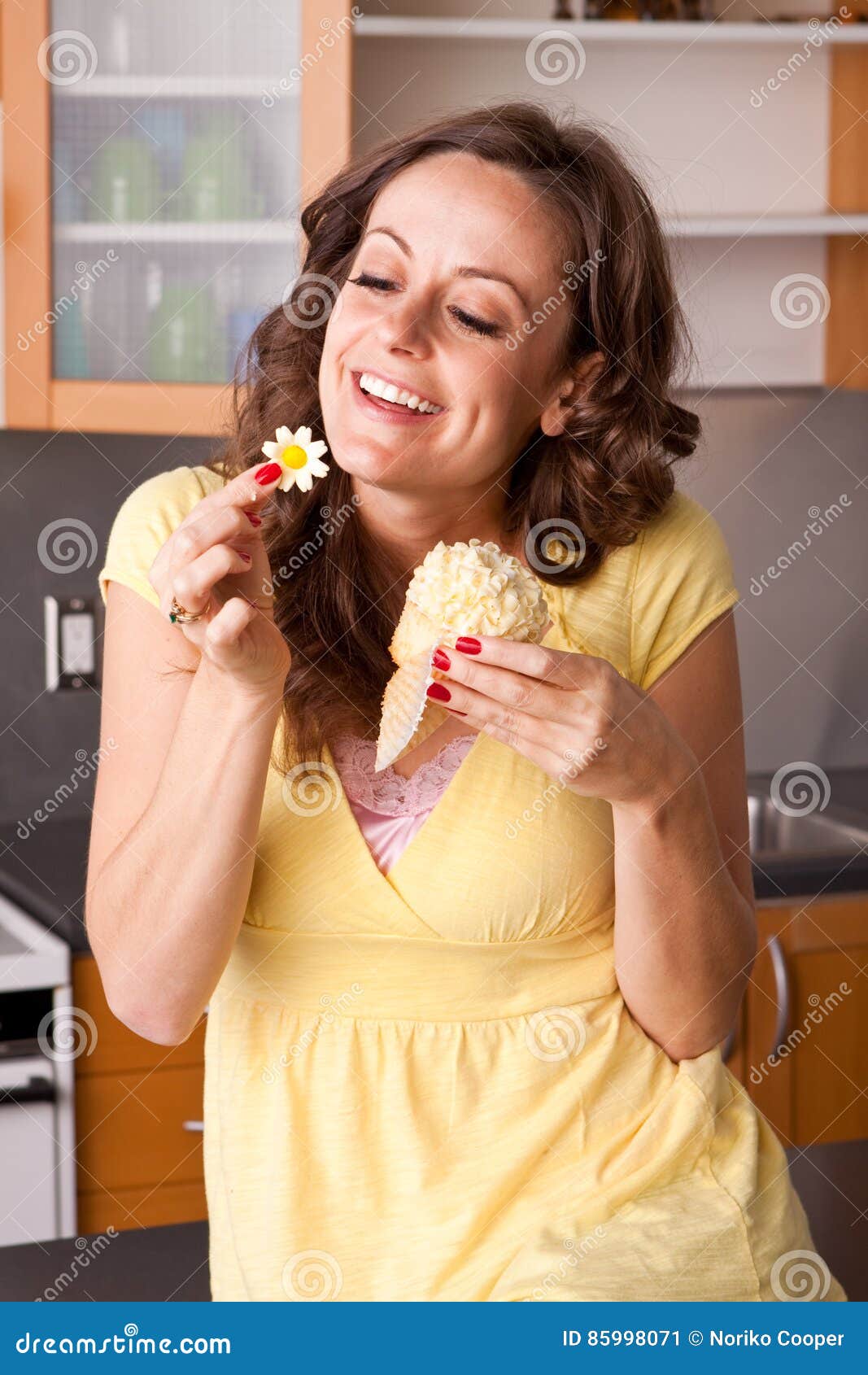 Woman Eating a Cupcake in the Kitchen. Stock Image Image of