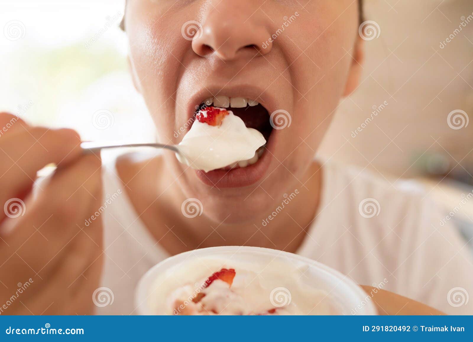 Woman Eating Yogurt during Breakfast in the Morning Stock Photo Image