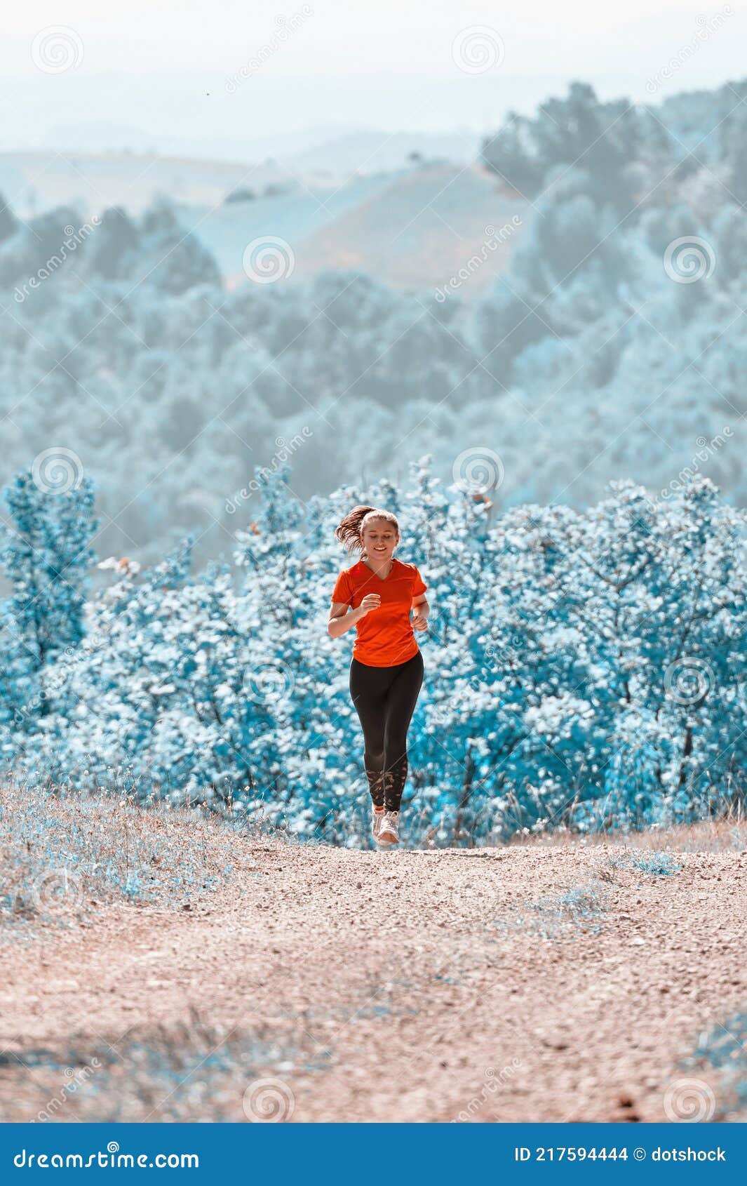 woman jogging on a country road through the beautiful sunny forest