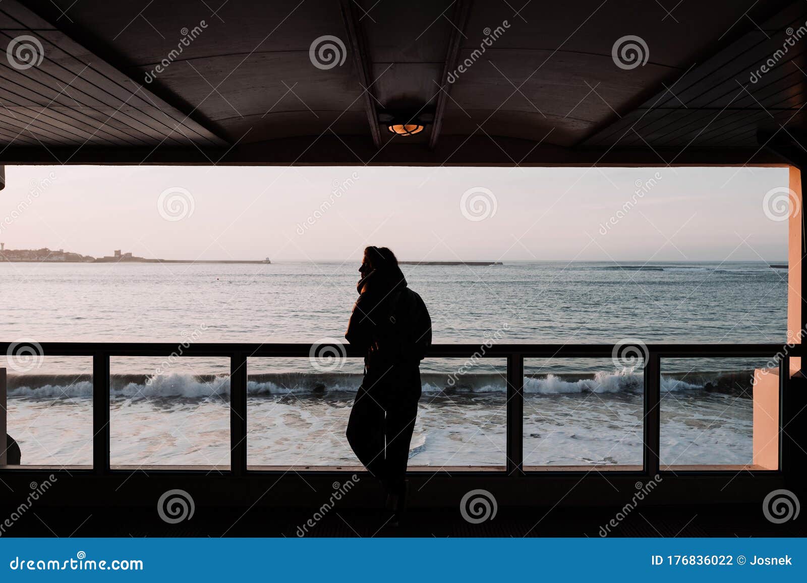 woman enjoying the sea from a viewpoint at sunset