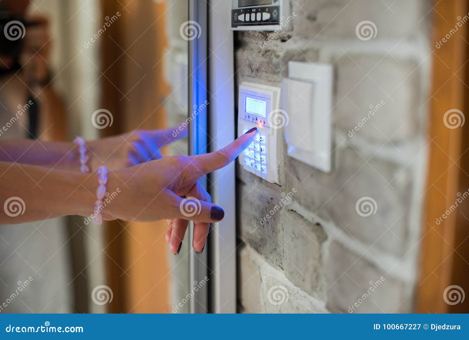 woman entering password on home alarm keypad.